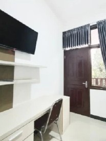 Suite room with TV, desk and door